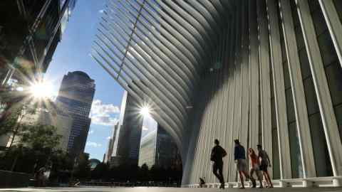 People walk through the plaza outside the Oculus transit hub at One World Trade Center as the sun sets on June 24 in New York City