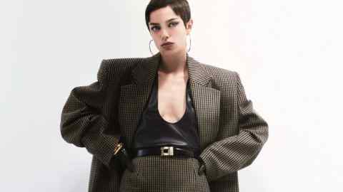 Saint Laurent by Anthony Vaccarello wool jacket, £2,650, matching skirt, £1,320, leather tank top, £1,890, leather belt, £405, and metal hoop earrings, POA