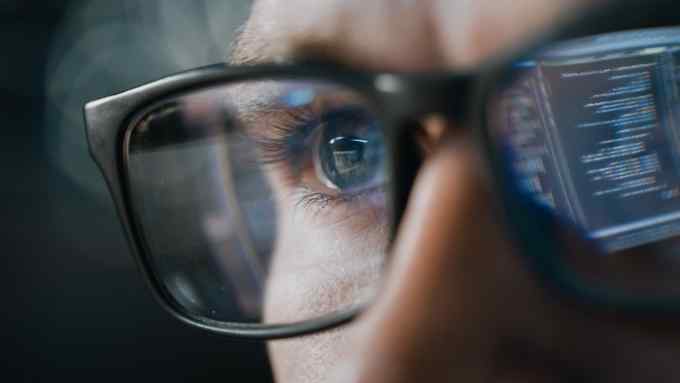 Close-up Portrait of Software Engineer Working on Computer, Line of Code Reflecting in Glasses