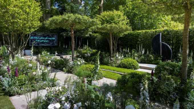 A garden designed with trees, shrubs, flowers and concrete pavement