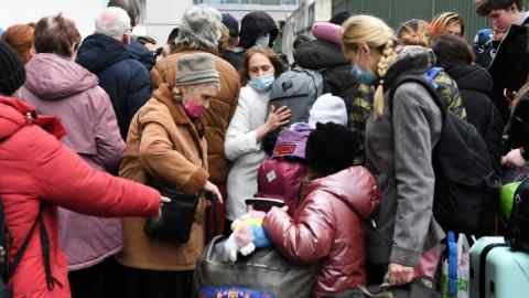 Ukrainians queue outside a centre for refugees in Paris on Thursday