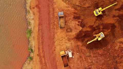 Aerial view of excavators and trucks at a nickel mine in Indonesia