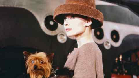 Audrey Hepburn with a dog on the set of Funny Face, 1956