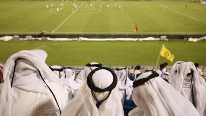 Qatari football fans watch a football game at Doha’s Al Gharafa Stadium