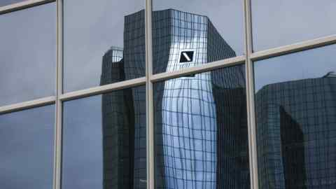 The headquarters of Deutsche Bank reflected in the windows of an office building in the financial district of Frankfurt