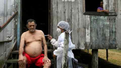 A health worker administers the Oxford/AstraZeneca vaccine to those living along the Solimões river in Brazil this week