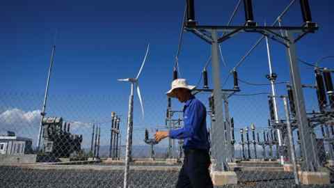 a man walking past power installations at the Phu Lac wind farm in southern Vietnam’s Binh Thuan province
