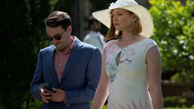 A man and a woman in smart summer clothes walk