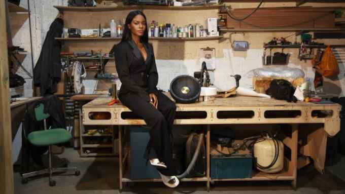 Mimi Shodeinde sits on a desk in her London studio
