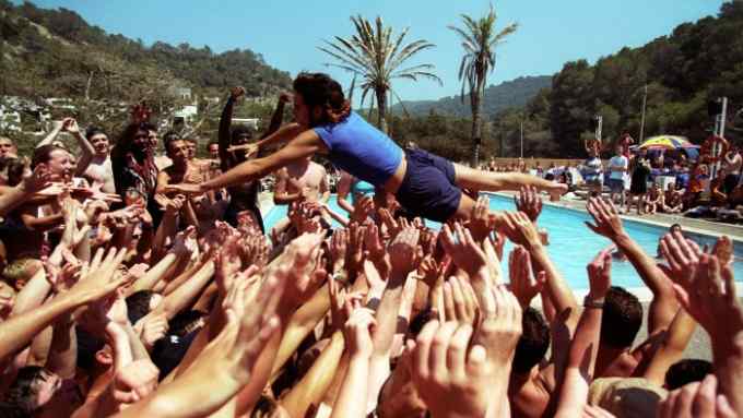 A holiday rep diving into a crowd of people, at a pool party, Club 18-30 Ibiza, 2001. (Photo by: PYMCA/Universal Images Group via Getty Images)
