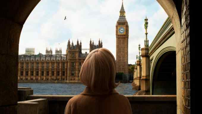A woman views Westminster and the Big Ben across the Thames