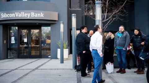 Silicon Valley Bank customers listen as FDIC representatives, left, speak with them before the opening of a branch SVBs headquarters in Santa Clara, California, on March 13, 2023.