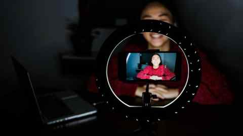 A woman filming herself on a smartphone