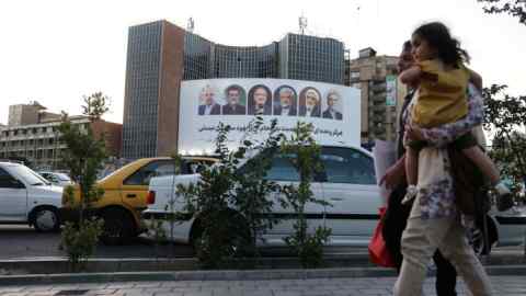 A billboard with a picture of the presidential candidates is displayed on a street in Tehran