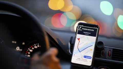 A dashboard-mounted smartphone displays a map of the ‘Mainhattan’ financial district on the Uber Technologies Inc. app