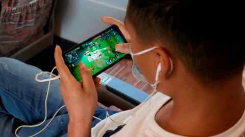 A man plays an online game from Chinese gaming platform Tencent on a train from Henan to Beijing.