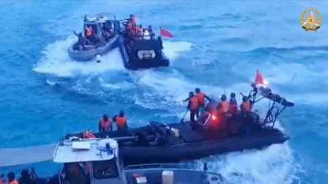 A frame grab of video footage shows Chinese coastguard personnel aboard rigid hull inflatable boats during a confrontation with Philippine navy personnel on their respective vessels  near the Second Thomas Shoal in disputed waters of the South China Sea on June 17