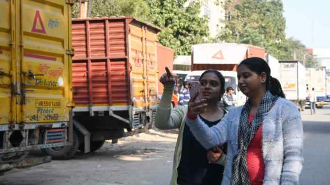 Safetipin’s process team members Toshi Saini (left) and Priya Kaushik (right) demonstrate (outside their Gurugram office) how data is collected by photographing streets and locations on the Safetipin smartphone app