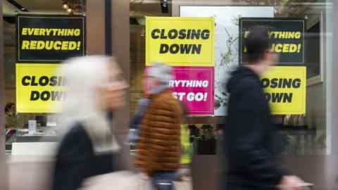 Shoppers pass a store displaying ‘Closing Down’ sale signs on Oxford Street, London