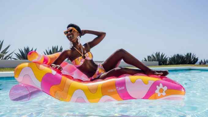 woman in a bikini on top of an inflatable pool bed