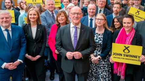 John Swinney with SNP supporters and fellow MSPs after a press conference at the Grassmarket Community Project in Edinburgh on Thursday