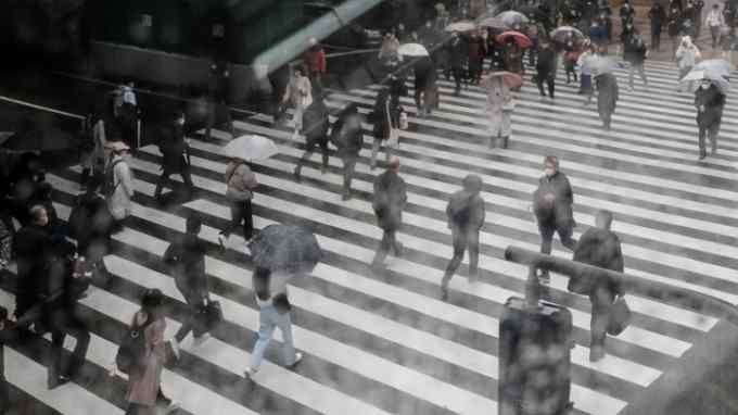 Pedestrians cross a road in Osaka, Japan, on Monday, Feb. 13, 2023.