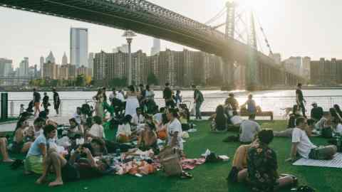 People picnicking in a park under a bridge in New York