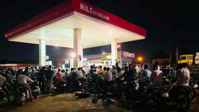 Motorcyclists queue at a petrol station in Khartoum: Some citizens report waiting in line for two days to refill vehicles