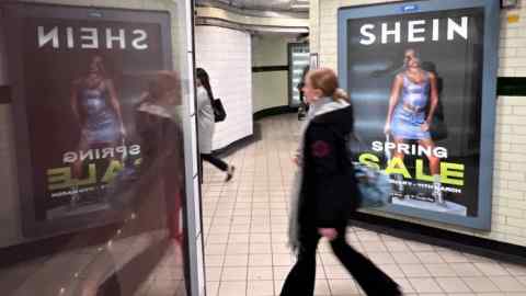 A person walking past a Shein billboard in London