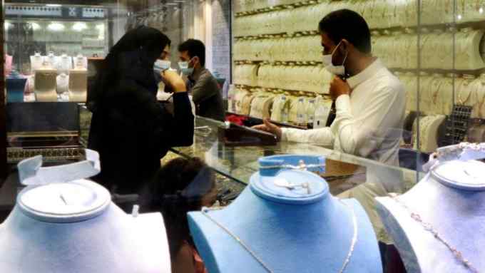 Saudi citizens buy gold at a market the day before VAT increased from 5 to 15 per cent