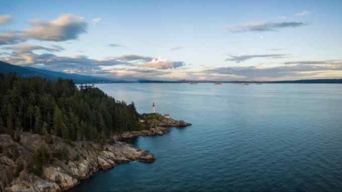 A rocky, forested promontory in Vancouver’s Lighthouse Park, looking over a bay and towards the city skyline