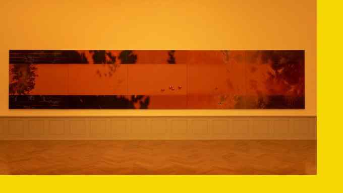 A long dark orange painting against a lighter orange wall