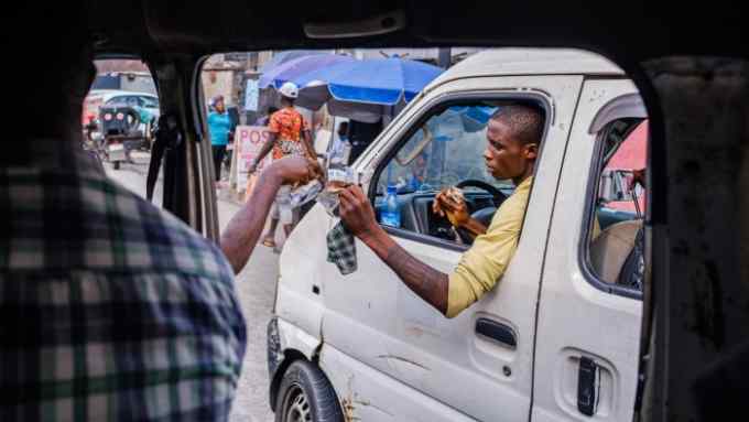 A passenger gives his transport fare to commercial vehicle driver