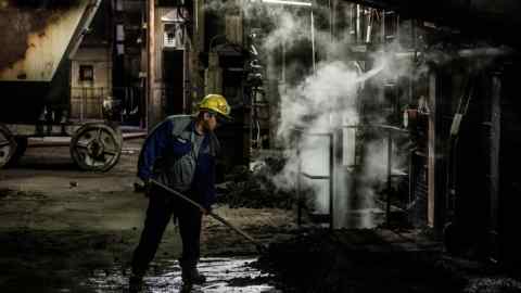 A worker clears debris at a coal power station
