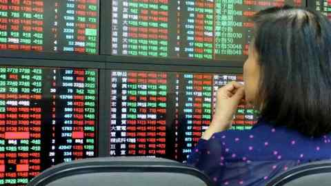An investor watches a monitor at a stock exchange in Taipei, Taiwan