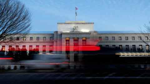 Vehicles drive past the Federal Reserve building in Washington