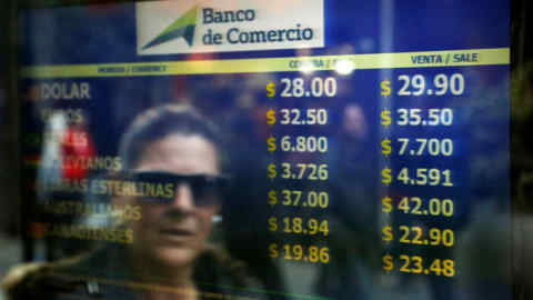 A woman walks past a currency exchange office in Buenos Aires at the time of the IMF's rescue package in June 2018. A large part of the IMF's money was spent on supporting the peso