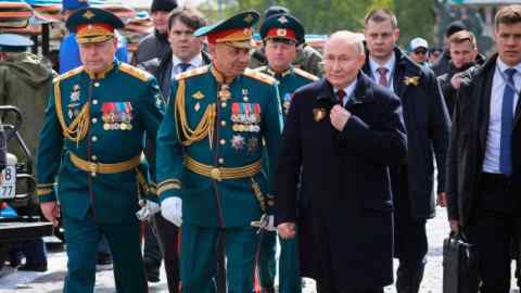 Vladimir Putin walks with Sergei Shoigu and other Russian officials