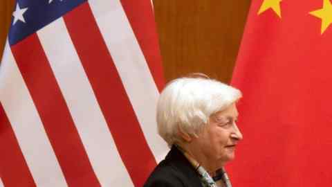 Janet Yellen in front of a US flag and a China flag