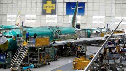 People work near the door of a 737 Max aircraft at the Boeing factory in Renton, Washington state