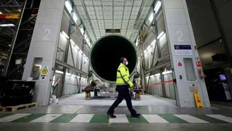 An employee walks past a wind turbine blade being manufactured at the Siemens Gamesa blade factory in Hull, UK