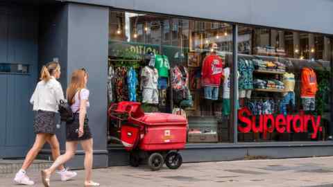 People walking outside a Superdry store