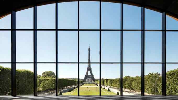 View of the Eiffel Tower through a large glass window