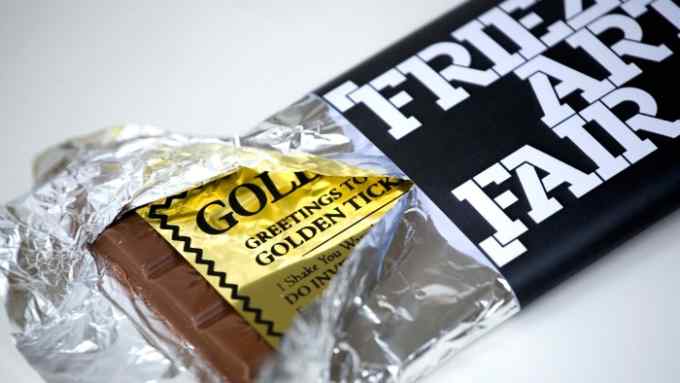 A chocolate bar tucked inside its wrapper with a golden ticket. The wrapper says  ‘Frieze Art Fair’ in blocky letters.