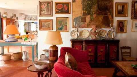 bright room stuffed with antiques, painting and bright colours; tiles on floors and walls