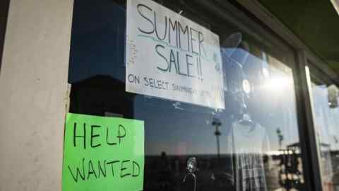 ‘For sale’ and ‘help wanted’ signs hang in a US shop window