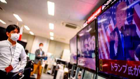 Staff at a trading company in Tokyo watch a live broadcast of Donald Trump speaking during election night in the US in November 2020