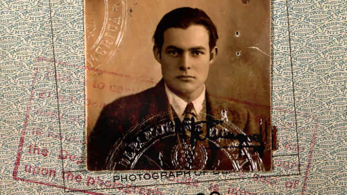A black and white passport photo of Ernest Hemingway
