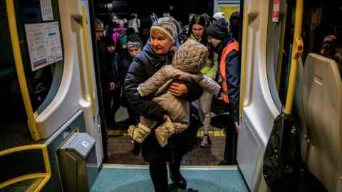 A Ukrainian refugee boards a train in Poland