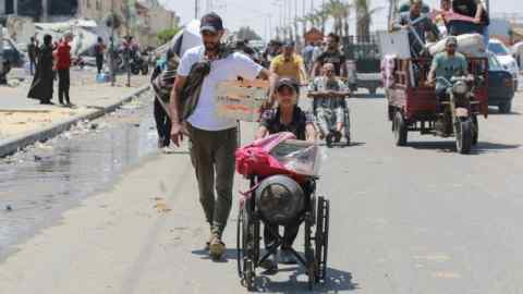 Palestinians flee with their belongings on foot or in vehicles